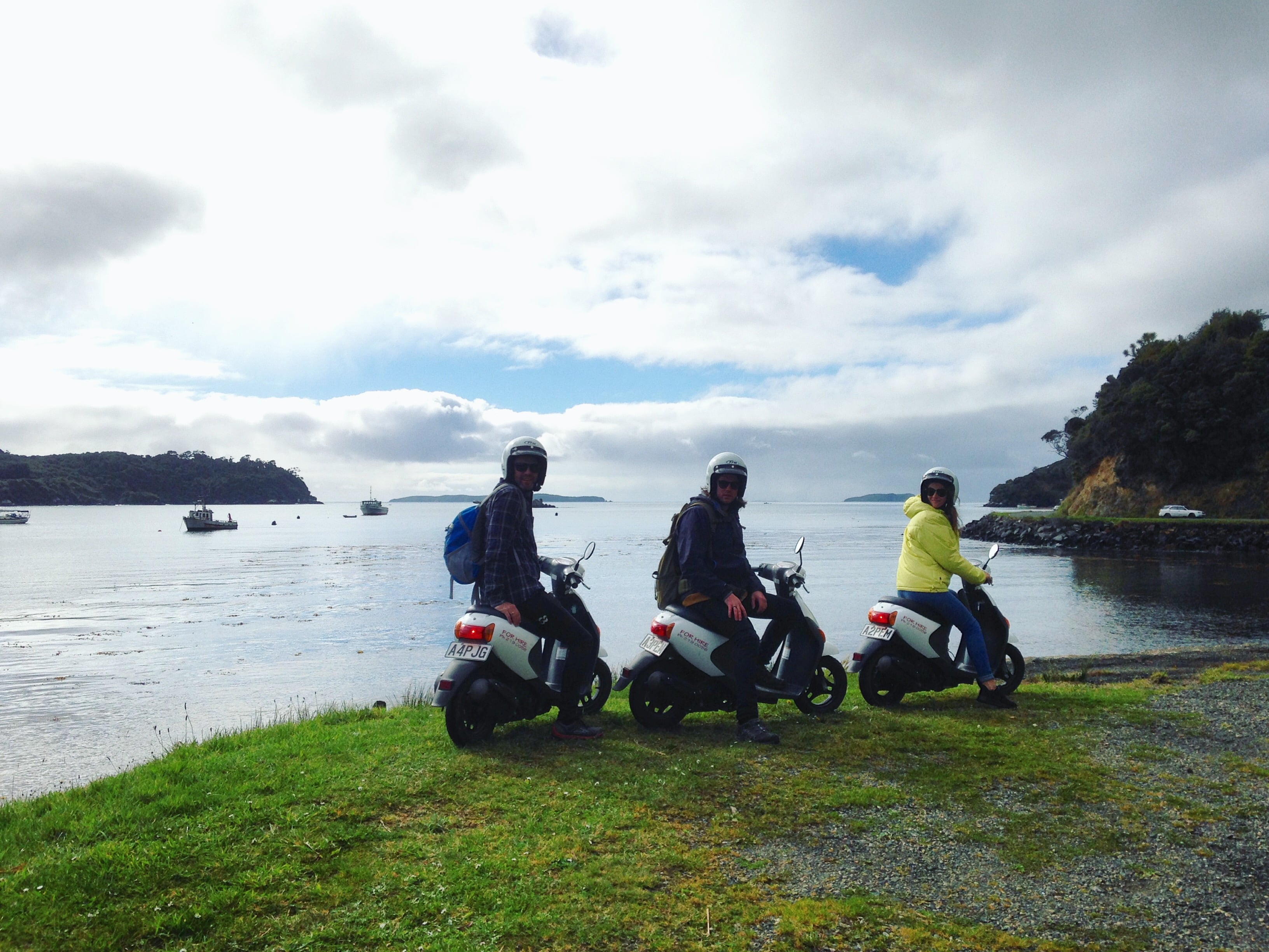 Three visitors to Stewart Island park their scooters on the coast of the island 