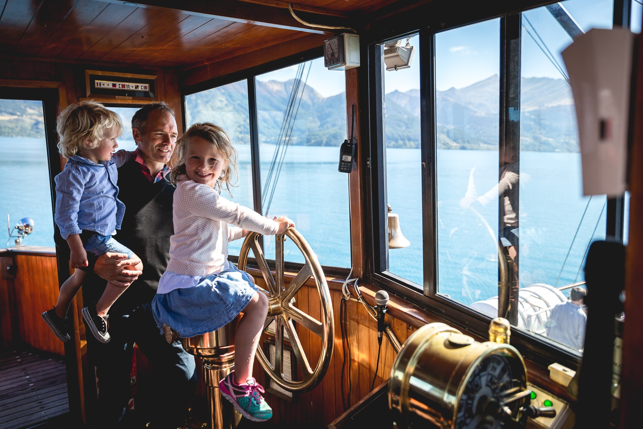 A young girl takes the wheel of the TSS Earnslaw steamship while cruising
