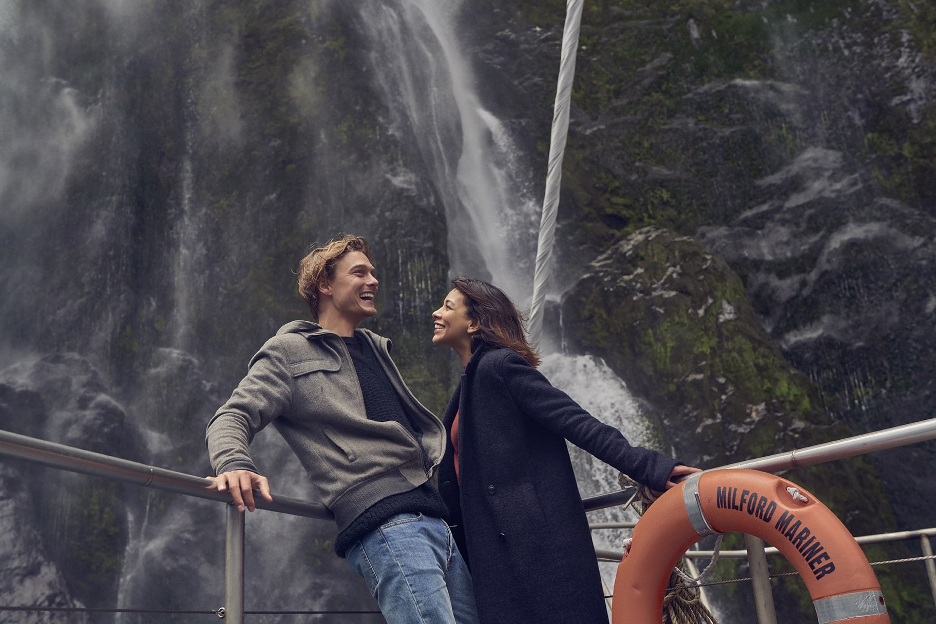 Couple in front of waterfalls in milford sound
