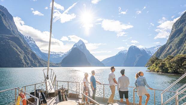 Group of friends sightseeing on a boat cruising Milford Sound