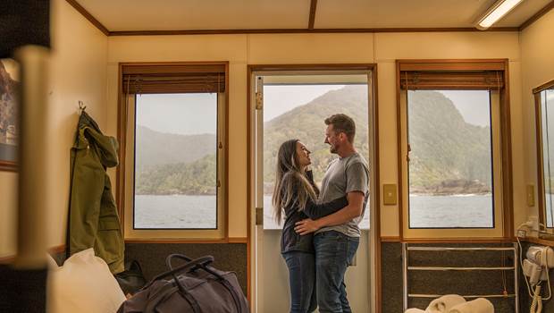 Couple embrace outside their cabin on board the Doubtful Sound Overnight Cruise
