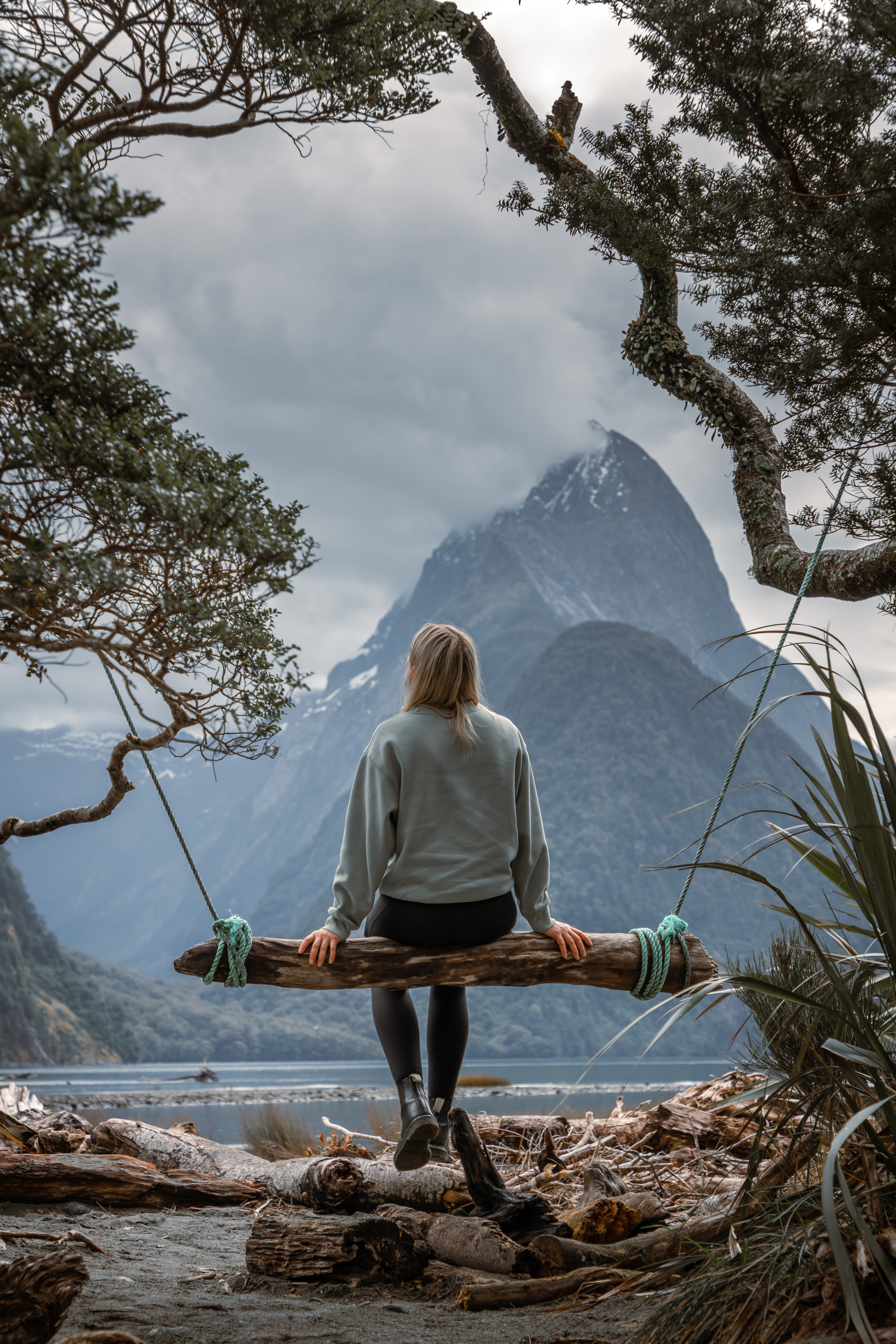 Woman sitting on swing in Milford Sound